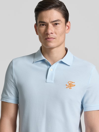 Männermodel trägt Regular Fit Poloshirt aus reiner Baumwolle von Tommy Hilfiger, Optik: Unifarben, Logo-Stitching, Piqué, Nahaufnahme Oberkörper.
