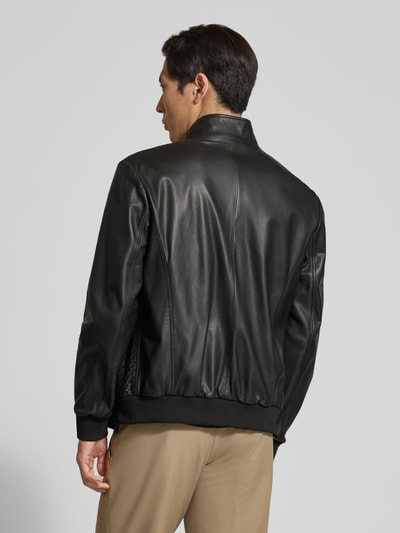 Männermodel trägt Lederjacke aus Lammleder mit Eingrifftaschen von Emporio Armani in Schwarz, gerader Schnitt, elastische Abschlüsse, Ganzkörperansicht Rückansicht.