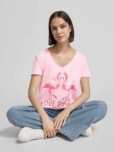 Frauenmodel trägt Damen T-Shirt mit Motiv-Print Modell 'Flamingo Love Me' von miss goodlife in Rosa, Regular-Fit, V-Ausschnitt, Nahaufnahme Oberkörper. Rückenlänge bei Größe S: 66 cm.