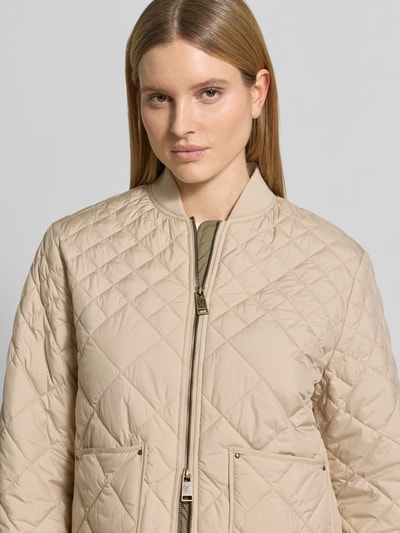 Frauenmodel trägt Steppjacke mit Eingrifftaschen von Fuchs Schmitt, beige Farbe, gesteppte Struktur, Nahaufnahme Oberkörper.
