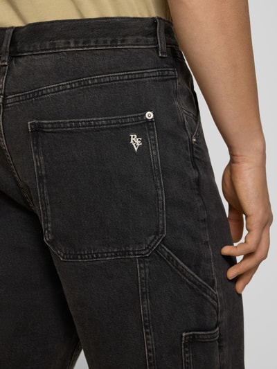 Männermodel trägt Bermudas mit seitlichen Eingrifftaschen und Gesäßtaschen von REVIEW aus Baumwoll-Mix mit Stretch-Anteil in dunklem Farbton, Detailaufnahme Gesäßtasche.