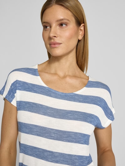Vrouwenmodel draagt Regular Fit T-Shirt uit viscosemix model 'WIDE STRIPE' van Vero Moda in meerkleurige streep, fijne breistructuur, U-boothals, labelstiksel, korte mouw, afgeronde zoom, asymmetrisch, detailopname bovenlichaam.