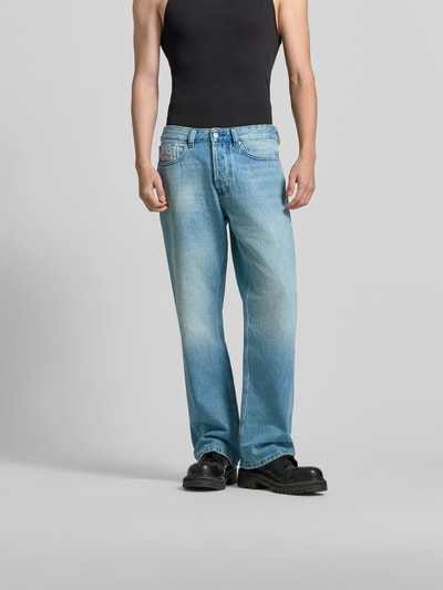 Männermodel trägt Flared Fit Jeans mit Logo-Patch von Diesel in Hellblau, 5-Pocket-Design, Baumwolle, Ganzkörperansicht von vorne.