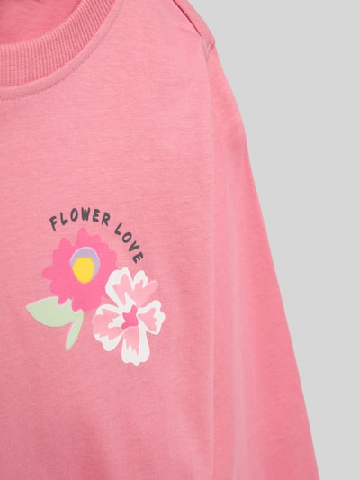 Mädchen trägt Regular Fit Sweatshirt aus reiner Baumwolle Modell 'JOAN' von Only, Motiv-Print, unifarben rosa, Nahaufnahme Oberkörper.