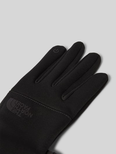 Produktfoto, schwarze Fingerhandschuhe mit Logo Modell 'ETIP' von The North Face, glatte Textur, Herrenhandschuhe, Kontext: Herren Handschuhe von The North Face, körpernahe Passform, Fingerhandschuhe, Modell 'ETIP', Logo
