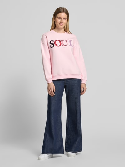 Frauenmodel trägt Sweatshirt mit Soul Stickerei von Smith and Soul in Rosa, Motiv-Print, Rundhals, langarm, Baumwollmix, Ganzkörperansicht von vorne.