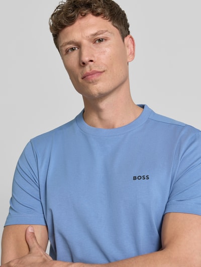 Männermodel trägt Regular Fit T-Shirt aus Baumwoll-Mix Modell 'TEE' von BOSS Green in Hellblau mit Label Print, Nahaufnahme Oberkörper.