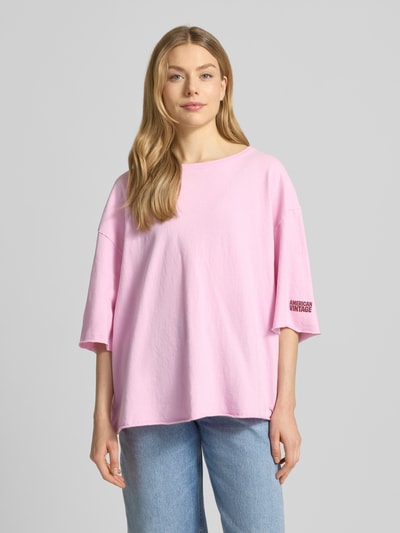Frauenmodel trägt Oversized T-Shirt mit Label-Print Modell 'YKOBOW' von American Vintage in Rosa aus Reine Baumwolle, Ganzkörperansicht von vorne.