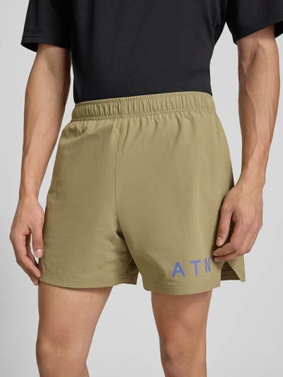 Männermodel trägt Shorts mit elastischem Bund und Label-Print von HALO, beige, glatte Textur, Regular Fit, Nahaufnahme Oberkörper.