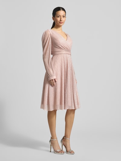 Kobiece modelka nosi Regular Fit Kleid in Wickel-Optik od TROYDEN COLLECTION, błyszcząca siateczka, różowy, długość tyłu 90 cm, krój taliowany, długość rękawa 67 cm, szerokość w rozmiarze 36: 37 cm, wszyty zamek błyskawiczny, dekolt w serek, długie rękawy, zakończenia rękawów obszyte, widok całej sylwetki z przodu.
