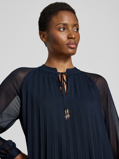 Vrouwenmodel draagt donkerblauw a-lijn businesskleed in plissé-look model 'Daphne' van JOOP!, nahaufnahme bovenlichaam.