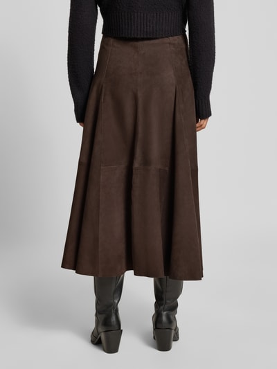 Frauenmodel trägt Midirock aus echtem Leder Modell 'Kilar' von Cph Muse, A-Linie, braun, Reißverschluss, Ganzkörperansicht Rückansicht. Bundweite bei Größe S: 38 cm, Gesamtlänge: 84 cm.