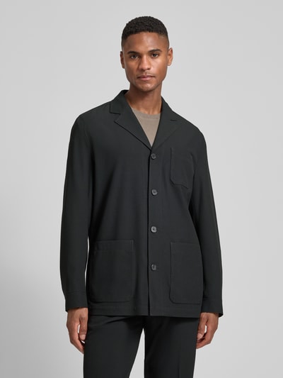 Männermodel trägt Relaxed Fit Hemdjacke mit Viskose-Anteil Modell 'Bill' von DIGEL in Schwarz mit aufgesetzten Taschen, Ganzkörperansicht von vorne.