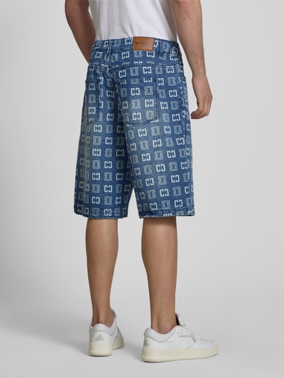 Männermodel trägt Straight Fit Jeans in Denim-Optik mit Allover-Logo-Print von COLUCCI, Reine Baumwolle, 5-Pocket-Design, Ganzkörperansicht Rückansicht