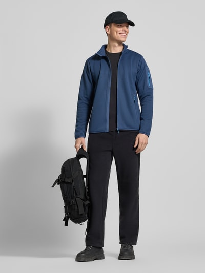 Männermodel trägt Regular Fit Jacke mit Stehkragen Modell 'BREDSTEDT' von Icepeak in Blau, sichtbare Reißverschlüsse, Ganzkörperansicht von vorne, Herren Jacke, elastische Abschlüsse, Eingrifftaschen, Größe M: Rückenlänge 69 cm, Schulterbreite 43 cm, Brustweite 54 cm, Ärmellänge 67 cm.
