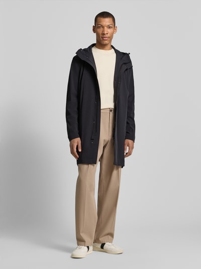 Männermodel trägt Regular Fit Funktionsmantel aus wasserabweisendem Material von Strellson, unifarben, mit Kapuze, Ganzkörperansicht von vorne.