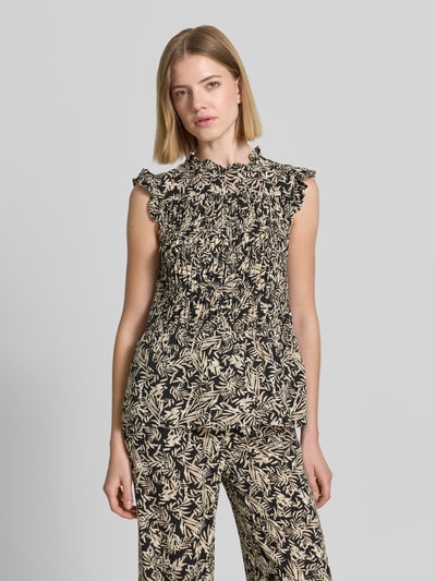 Frauenmodel trägt Blusentop aus Reine Viskose mit Rüschenkragen Modell 'FAYE' von Soyaconcept, Körpernaher-Schnitt, Rüschenärmel, Smok-Detail, Rückenlänge bei Größe S 58 cm, florales Muster in Schwarz und Beige, Ganzkörperansicht von vorne.
