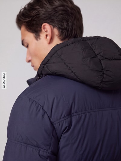 Männermodel trägt Regular Fit Steppjacke mit Kapuze Modell 'Bodo2541' von HUGO, dwukolorowy, popelina, hydrofobowy, naszywka z logo, Ganzkörperansicht Rückansicht, KI-modifiziertes Bild