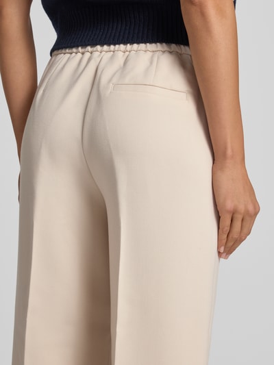 Vrouwenmodel draagt cropped stoffen broek met viscose van someday, bandplooien, steekzakken, achterzak, elastische band, model 'Curilo', detailopname achterkant.