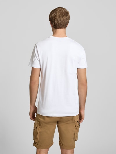 Männermodel trägt T-Shirt mit Logo und Rundhalsausschnitt van Alpha Industries, wit katoen, regular fit, ruglengte 67 cm, ganzlichaamsaanzicht achterkant
