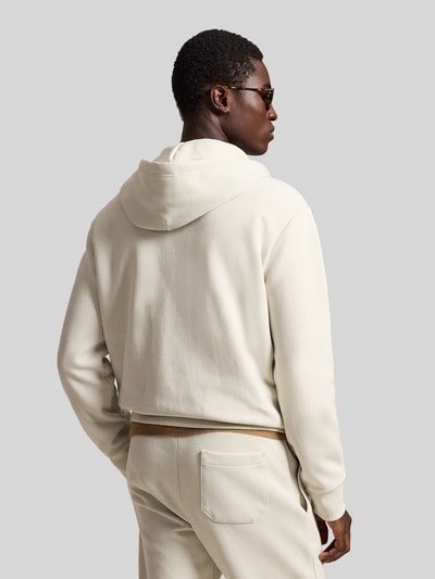 Męski model nosi Regular Fit Sweatjacke aus Baumwoll-Mix von Polo Ralph Lauren w kolorze kremowym, gładka faktura, widok z tyłu całej sylwetki
