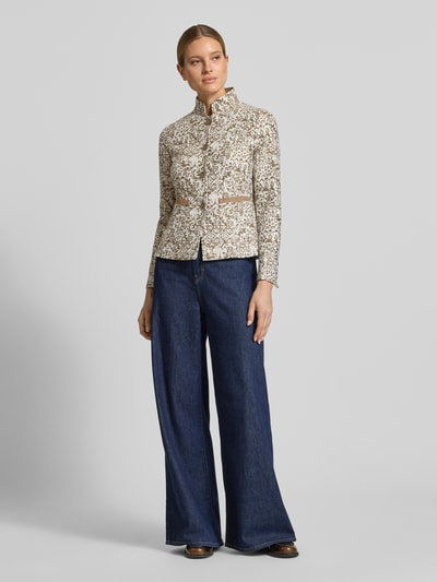 Modelka nosi Slim Fit Blazer im Allover-Look mit Stehkragen od WHITE LABEL, mieszanka bawełny, krój slim fit, wzór na całej powierzchni, stójka, listwa guzikowa, długość tyłu w rozmiarze 36: 62 cm, szerokość w rozmiarze 36: 46 cm, długość rękawów w rozmiarze 36: 63 cm, jasny beż z brązem, struktura gładka, widok całej sylwetki z przodu.