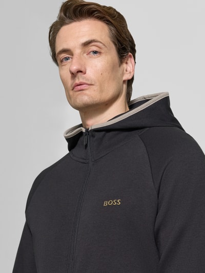 Männermodel trägt Regular Fit Sweatjacke aus Baumwoll-Mix von BOSS, unifarben, Kapuze, Reißverschluss, Nahaufnahme Oberkörper.