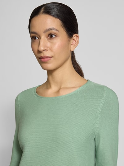 Vrouwenmodel draagt Regular Fit Pullover mit Strukturmuster van Christian Berg Woman in lichtgroen, puur katoen, ronde hals, elastische mouwboorden, detailopname bovenlichaam.