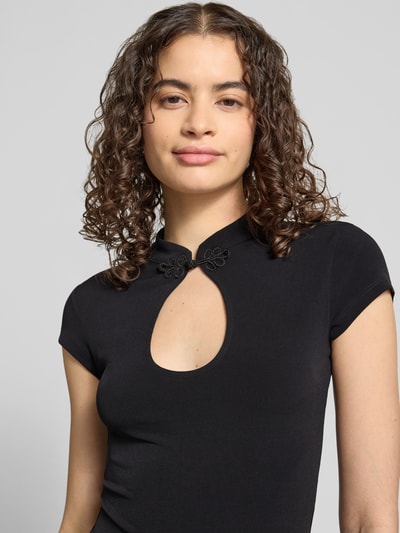 Frauenmodel trägt Slim Fit T-Shirt mit Cut Out von Gina Tricot aus Material-Mix mit Stretch-Anteil, Stehkragen, Rückenlänge 48 cm, Nahaufnahme Oberkörper.