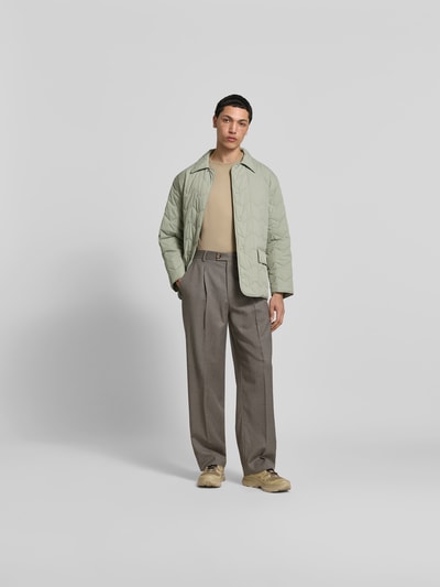 Männermodel trägt Regular Fit Jacke in Stepp-Optik von MAISON KITSUNÉ, helle Farbe, Struktur durch Stepp-Nähte, Ganzkörperansicht von vorne, Umlegekragen, Pattentaschen, durchgängige Knopfleiste, Rückenlänge bei Größe M 75 cm, Schulterbreite 48 cm, Ärmellänge 62 cm.