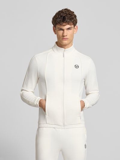 Männermodel trägt Slim Fit Tracksuit mit Logo-Stitching Modell 'Egeo' van SERGIO TACCHINI in gebroken wit, katoenmix, opstaande kraag, ritssluiting, elastische boorden, heren model, vooraanzicht bovenlichaam