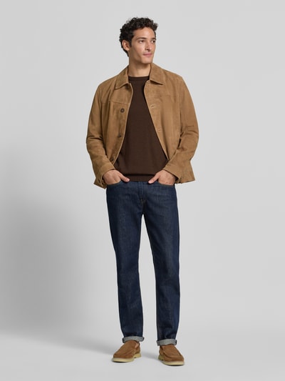 Männermodel trägt Regular Fit Pullover aus reiner Baumwolle von s.Oliver RED LABEL in Braun, kombiniert mit Jeans, Ganzkörperansicht von vorne.