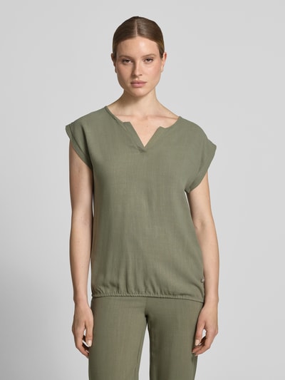 Frauenmodel trägt Regular Fit Bluse aus Viskose-Mix Modell 'Connie' von ZABAIONE, Tunika-Ausschnitt, Kurzärmelig, Ganzkörperansicht von vorne. Damen Bluse mit Leinen-Viskose-Mix und Rückenlänge bei Größe S: 60 cm, grüne Farbnuancen, glatte Textur.