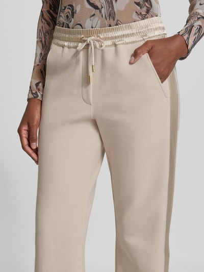 Frauenmodel trägt Sweatpants mit elastischem Bund und Tunnelzug von Marc Cain aus Baumwoll-Mix mit Stretch-Anteil, Nahaufnahme Oberkörper.