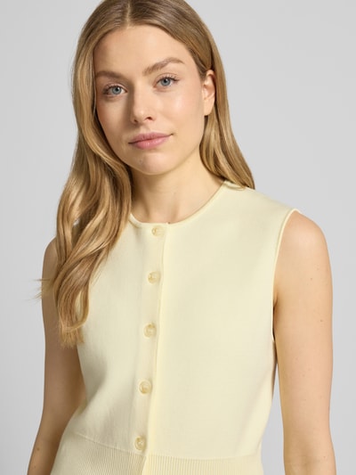 Vrouwenmodel draagt Strickweste aus Viskose-Mix mit Rundhalsausschnitt van Samsøe Samsøe, regular fit, model 'ANNE', lichte crèmekleur, fijne gebreide structuur, ronde hals, knoopsluiting, viscosemix met stretch, ruglengte maat S 50 cm, close-up bovenlichaam