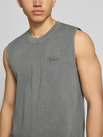 Męski model nosi szare Tanktop mit Logo-Stitching Modell 'Signar' od Pegador z czystej bawełny, prosty krój, okrągły dekolt, detal logo, rozmiar M długość tyłu 68 cm, zbliżenie na górną część ciała.
