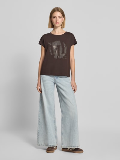 Frauenmodel trägt T-Shirt aus Viskose-Mix mit Ziersteinbesatz von monari, Regular Fit, Rundhalsausschnitt, Rückenlänge 56 cm, Ganzkörperansicht von vorne