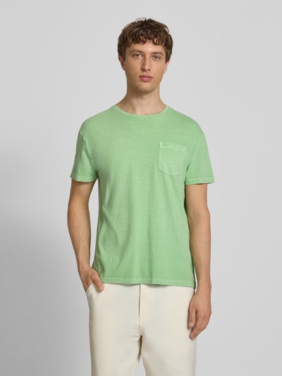 Männermodel trägt T-Shirt aus Baumwoll-Leinen-Mix mit Brusttasche von Superdry in Grün, Regular-Fit, Rundhalsausschnitt, Herren T-Shirt, Rückenlänge bei Größe M 66 cm, Ganzkörperansicht von vorne.