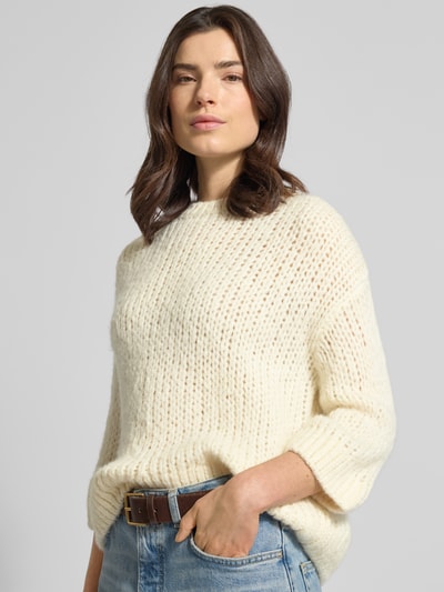 Frauenmodel trägt Regular Fit Pullover mit Woll-Alpaka-Anteil Modell 'Tariah' von Someday in Strick-Optik, cremefarben, Nahaufnahme Oberkörper.