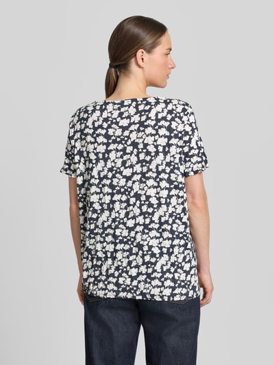 Frauenmodel trägt Regular Fit T-Shirt mit Viskose-Anteil von Tom Tailor, dunkelblauer Grund, weißes Blumenmuster, Damen T-Shirt, Ganzkörperansicht Rückansicht.