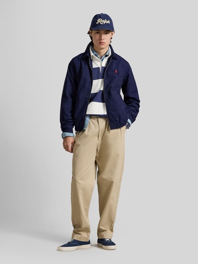Männermodel trägt Regular Fit Blouson aus reiner bawełna von Polo Ralph Lauren, efekt: jednolity kolor, krój regular fit, wykładany kołnierz, zamek błyskawiczny, detal z logo, długi rękaw, elastyczne zakończenia, wpuszczane kieszenie; Ganzkörperansicht von vorne.
