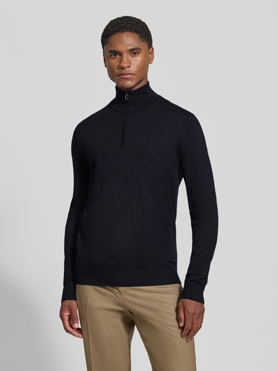 Männermodel trägt Modern Fit Troyer aus reiner Schurwolle Modell 'Dario' von JOOP! COLLECTION in Schwarz, Ganzkörperansicht von vorne.