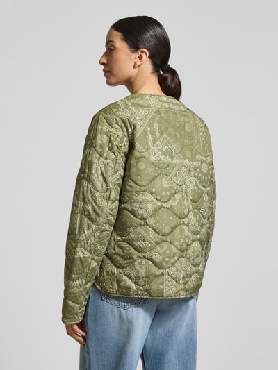 Kobiece modelka nosi Steppjacke mit Rundhalsausschnitt od camel active w kolorze oliwkowym z przeszyciami, prosty krój, długość pleców w rozmiarze 36: 60 cm, szerokość ramion w rozmiarze 36: 43 cm, szerokość w biuście w rozmiarze 36: 53 cm, długość rękawa w rozmiarze 36: 64 cm, widok całej sylwetki z tyłu.