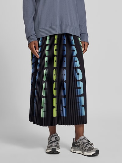 Frauenmodel trägt Midirock in Plissee-Optik von Marc Cain mit elastischem Bund und Logo-Details, bunte Streifen, Ganzkörperansicht von vorne.