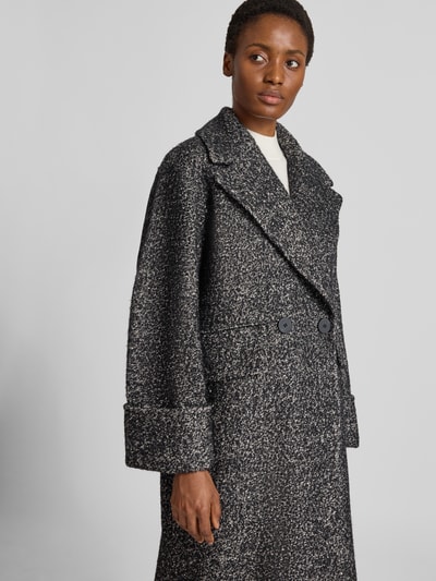 Frauenmodel trägt Mantel mit Woll-Anteil Modell 'ZAG' von Copenhagen Muse in Melange-Optik, Material-Mix, Zweireiher, Nahaufnahme Oberkörper.