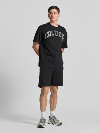 Männermodel trägt Herren T-Shirt mit 1/2-Arm von COLUCCI in Schwarz, Reine Baumwolle, Gerader Schnitt, Rundhalsausschnitt, Ganzkörperansicht von vorne.