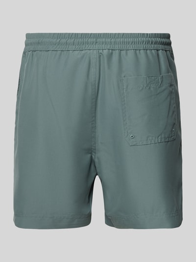 Produktfoto, Regular Fit Badeshorts mit Logo-Stitching Modell 'Chase' von Carhartt Work In Progress, zielona, matowa tkanina, elastyczny pas ze sznurkiem, wszyty slip, tylna kieszeń, kontekst: kąpielówki męskie