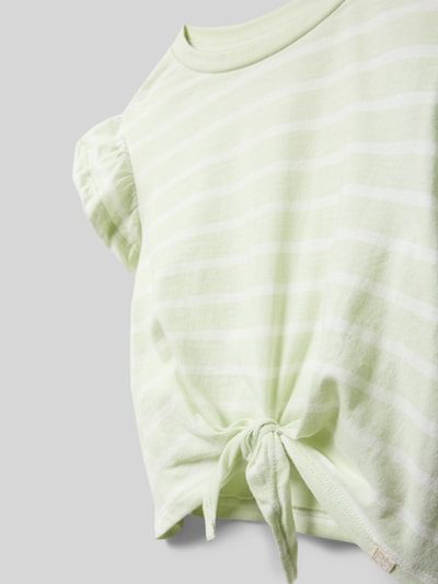 Meisje draagt Regular Fit T-Shirt uit pure katoen model 'KALINKA' van ONLY met allover-streeppatroon, knoopdetail, jersey structuur, ronde hals, korte mouw; detailopname.