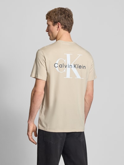 Männermodel trägt Regular Fit T-Shirt mit Logo-Print von Calvin Klein Jeans aus reiner Baumwolle, Rückansicht, Ganzkörperansicht Rückansicht.