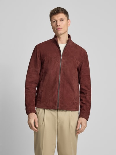 Männermodel trägt Regular Fit Lederjacke aus echtem Ziegenvelours Modell 'JIMMY-S' von Strellson, Optik: Unifarben, Passform: Regular-Fit, Kragenform: Stehkragen, Verschluss: Reißverschluss, Ärmelform: Langarm, Ärmelabschluss: Manschette, Taschen: Napoleontasche, seitliche Eingrifftaschen, Materialverarbeitung: Velours, Material: Ziegenleder, Ganzkörperansicht von vorne.